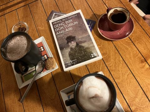 Okuduğumuz kitap ve masadaki içeçekler bulunmakta 